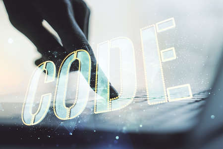 Creative Code word sign and hands typing on laptop on background, international software development concept. Multiexposureの写真素材