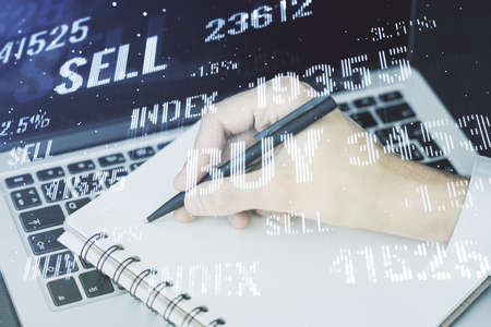 Multi exposure of abstract creative financial graph with hand writing in notepad on background, forex and investment conceptの写真素材