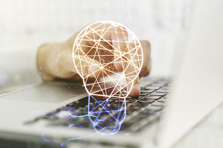 Creative light bulb hologram with hands typing on computer keyboard on background, idea concept....