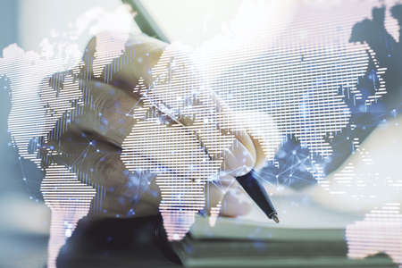 Double exposure of abstract digital world map and woman hand writing in notepad on background, big data and blockchain conceptの写真素材