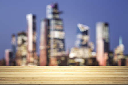 Empty tabletop made of wooden dies with blurry city view at dusk on background, templateの写真素材