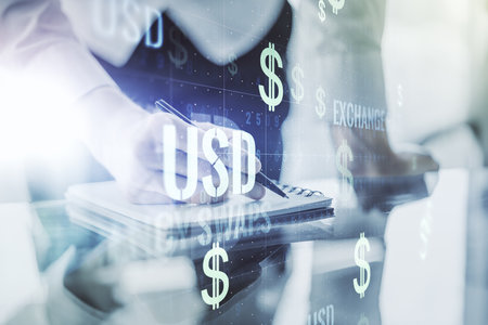 Creative concept of USD symbols illustration and man hand writing in notebook on background. Trading and currency concept. Multiexposureの写真素材