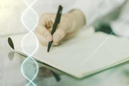 Creative light DNA illustration and man hand writing in diary on background, science and biology concept. Multiexposureの写真素材