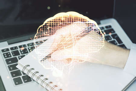 Double exposure of creative human brain microcircuit with hand writing in notepad on background with laptop. Future technology and AI conceptの写真素材