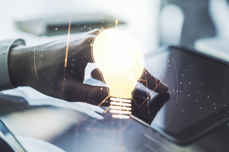 Double exposure of creative light bulb hologram with finger clicks on a digital tablet on...