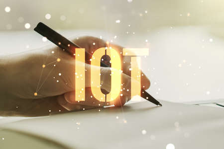 Double exposure of creative IOT hologram with man hand writing in notebook on background, research and development conceptの写真素材