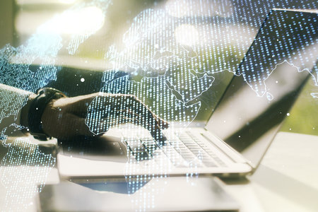 Multi exposure of abstract creative digital world map and hand typing on computer keyboard on background, research and analytics conceptの写真素材