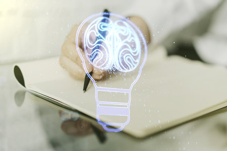 Double exposure of creative light bulb hologram with human brain and with man hand writing in notebook on background, idea and brainstorming conceptの写真素材