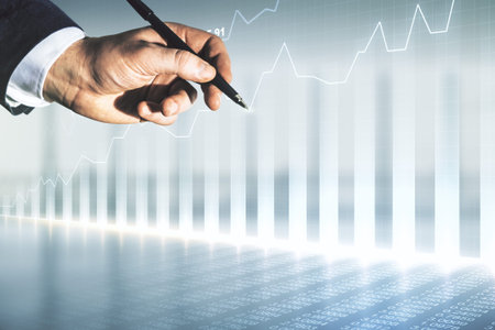 Man hand with pen working with abstract virtual financial graph on blurred office background,...