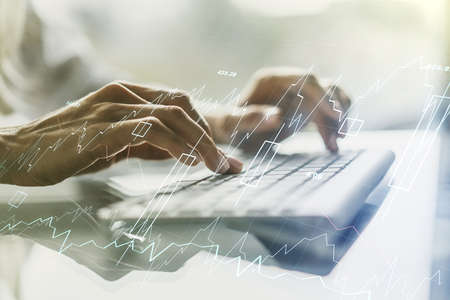 Abstract creative financial graph with hand typing on laptop on background, forex and investment concept. Multi-exposureの写真素材