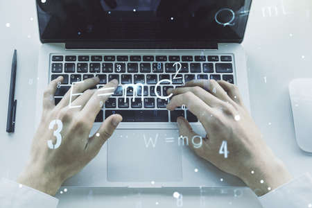 Creative scientific formula concept with hands typing on laptop on background. Multi-exposureの写真素材