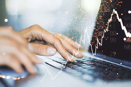 Double exposure of abstract creative financial chart with world map and with hands typing on computer keyboard on background, research and strategy conceptの写真素材
