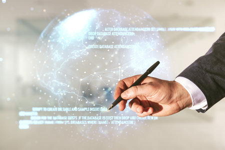 Male hand with pen working with abstract virtual coding illustration and world map on blurred office background, international software development concept. Multiexposureの写真素材