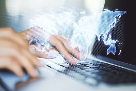 Double exposure of abstract digital world map and hand typing on laptop on background, research and strategy conceptの写真素材