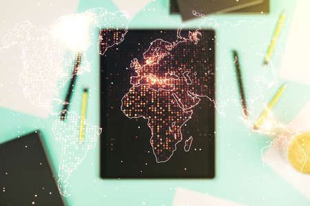 Abstract creative world map and modern digital tablet on background, top view, international trading concept. Multiexposureの写真素材