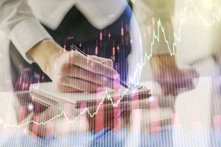 Multi exposure of abstract financial graph with world map and with man hand writing in diary on...