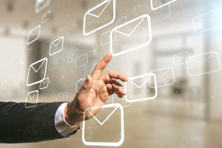 Double exposure of male hand presses on abstract virtual postal envelopes hologram on blurred office background. Electronic mail and spam conceptの写真素材