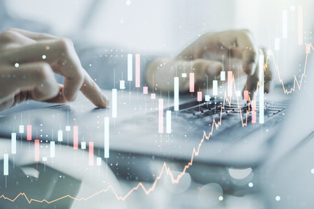 Multi exposure of abstract financial graph with hand typing on laptop on background, financial and trading conceptの写真素材