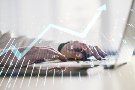 Multi exposure of abstract financial graph with upward arrow and hand typing on computer keyboard on background, financial and trading conceptの写真素材
