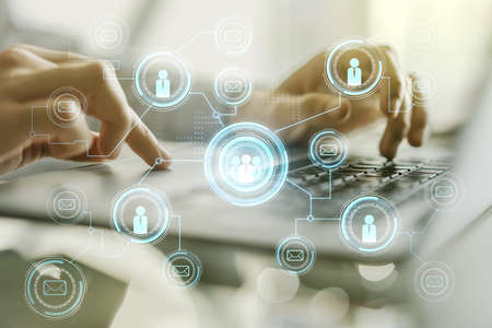 Double exposure of social network icons concept with hand typing on computer keyboard on background. Networking conceptの写真素材