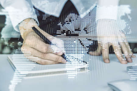Abstract creative digital world map and hand writing in diary on background with laptop, globalization concept. Multiexposureの写真素材