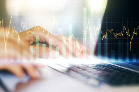 Double exposure of abstract creative financial diagram with hand typing on computer keyboard on background, banking and accounting conceptの写真素材