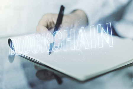 Creative concept of blockchain technology and man hand writing in notebook on background. digital...