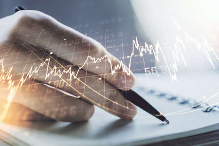 Double exposure of abstract creative financial diagram with hand writing in notebook on background, banking and accounting conceptの写真素材