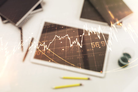 Abstract creative financial graph and modern digital tablet on background, top view, forex and...