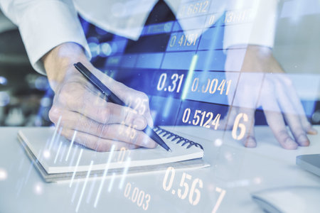 Double exposure of abstract creative financial diagram with hand writing in notebook on background,...