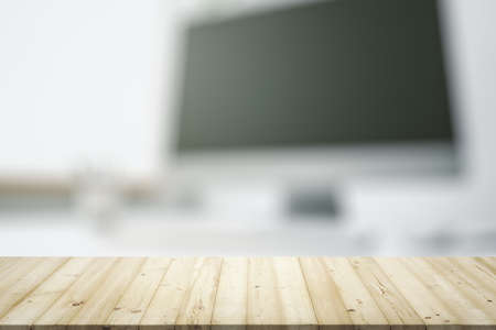 Empty wooden office table with light sunny workplace with computer on background, mock upの写真素材