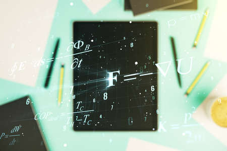 Creative scientific formula illustration and modern digital tablet on desktop on background, top view, science and research concept. Multiexposureの写真素材