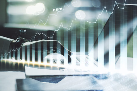 Double exposure of abstract creative financial chart with hand typing on computer keyboard on...