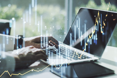 Double exposure of abstract creative financial diagram with hand typing on computer keyboard on...