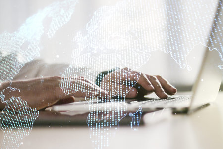 Double exposure of abstract digital world map and hand typing on laptop on background, research and...
