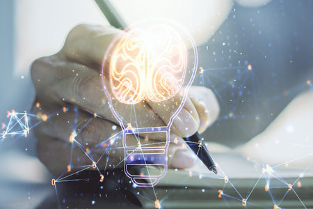 Creative light bulb illustration with human brain and with woman hand writing in diary on...