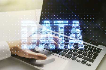 Creative Data word hologram and hands typing on computer keyboard on background, big data and blockchain concept. Multiexposureの写真素材