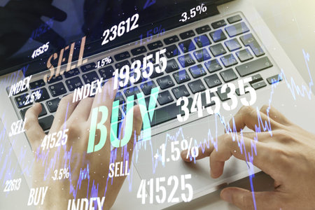 Abstract creative financial graph with hand typing on laptop on background, financial and trading...