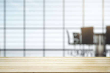 Empty office wooden desktop with empty space on modern boardroom with large window background, closeup, mock upの写真素材