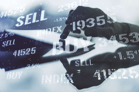 Abstract creative financial graph with finger clicks on a digital tablet on background, financial and trading concept. Multiexposureの写真素材