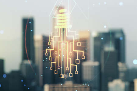 Double exposure of virtual creative light bulb hologram with chip on blurry cityscape background, idea and brainstorming conceptの写真素材