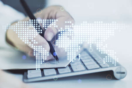 Double exposure of abstract digital world map and hand writing in notepad on background with laptop, big data and blockchain conceptの写真素材