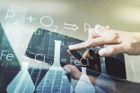 Creative chemistry illustration with finger presses on a digital tablet on background, science and research concept. Multiexposureの写真素材