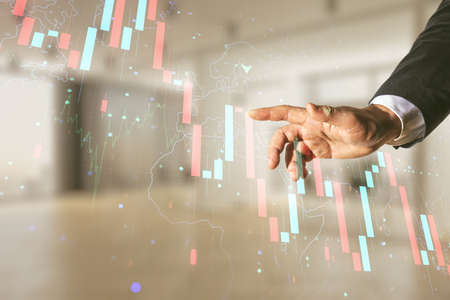 Man hand clicks on economic crisis chart and world map hologram on blurred office background, bankruptcy and recession concept. Multiexposureの写真素材
