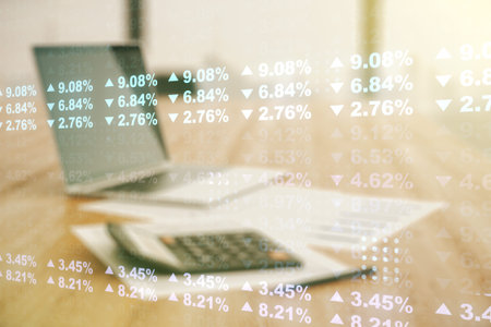 Double exposure of abstract virtual statistics data hologram on blurry calculator with laptop...