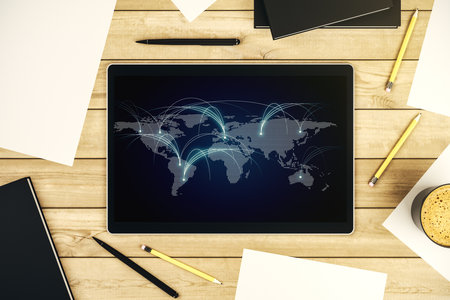 Top view of modern digital tablet monitor with abstract world map with connections, research and strategy concept. 3D Renderingの写真素材