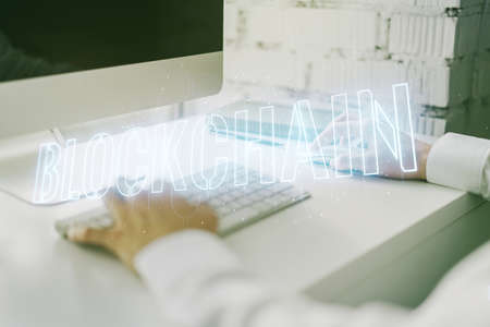 Creative abstract blockchain technology hologram and hands typing on computer keyboard on background, cryptography and decentralization concept. Multi exposureの写真素材