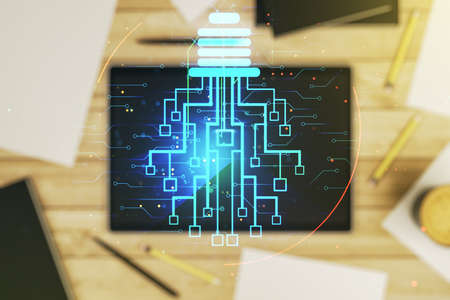 Creative light bulb illustration with microcircuit and modern digital tablet on desktop on background, top view, future technology concept. Multiexposureの写真素材