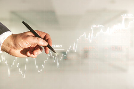 Multi exposure of businessman hand with pen working with virtual creative financial chart hologram...