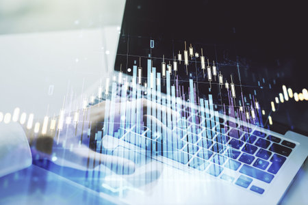 Double exposure of abstract creative financial chart with hand typing on computer keyboard on...